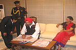 Tapi Mra detailing on the routes to the Governor, while First lady looks on.